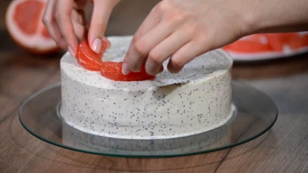 Ženské ruce zdobí dort s grapefruity - Záběry, video