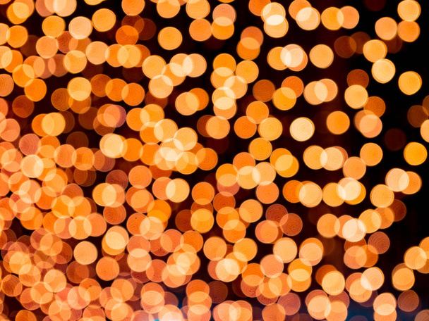 Oranje wazig bokeh licht intreepupil achtergrond en ribbels en noppen, voor Kerstmis, Nieuwjaar, feestdagen en viering achtergrond - Foto, afbeelding