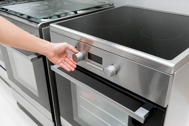 女性の手の熱オーブン マシンのボタンを調整します。 - 写真・画像