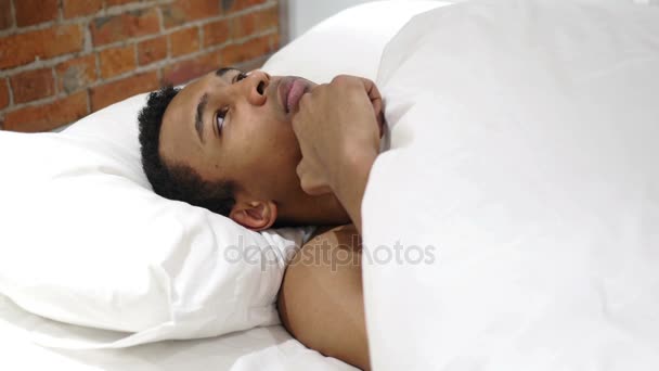 Αφρικανική άνθρωπος σε ξαπλωμένη στο κρεβάτι σκέφτεται και να φαντάζονται τη νύχτα - Πλάνα, βίντεο