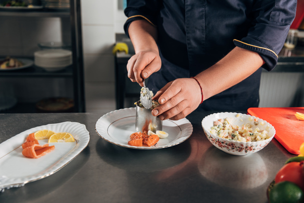 обрізаний знімок шеф-кухаря готує салат з металевою трубкою в ресторані
 - Фото, зображення