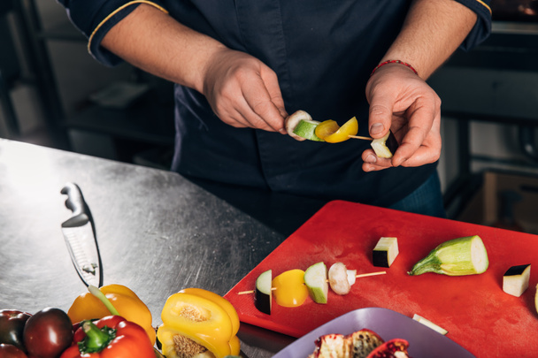 cropped shot of chef piercing vegetables on sticks for grill - Valokuva, kuva