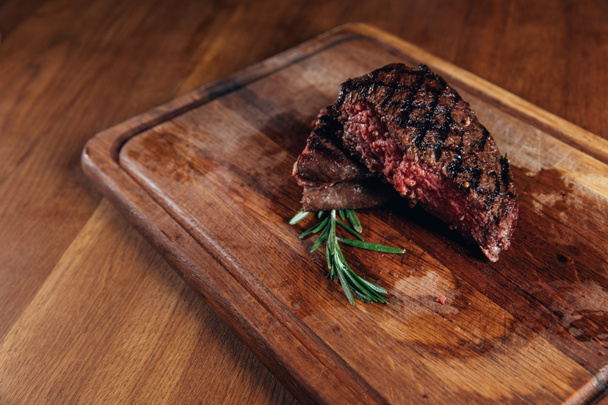 middelgrote zeldzame gegrilde steak op houten bord - Foto, afbeelding