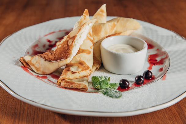 deliciosos crepes laminados con requesón servido en plato blanco con mermelada
 - Foto, Imagen