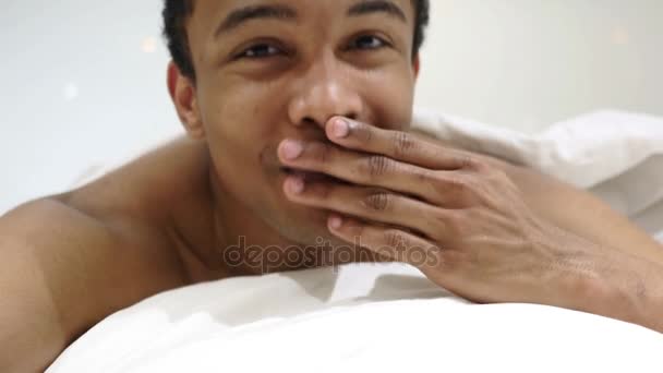 Letící polibek rukama, africký muž ležící v posteli - Záběry, video