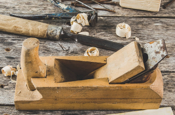 Плотник инструменты на деревянной скамейке, плоскость, зубило, молоток, щипцы, плоскогубцы, гвозди
 - Фото, изображение