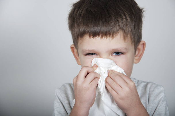 sick child blows his nose in a handkerchief - Фото, зображення