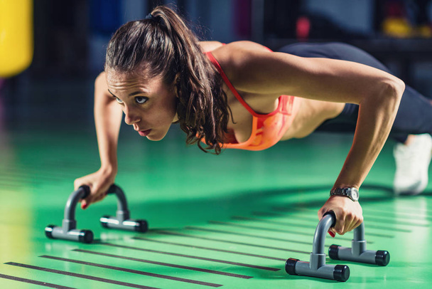 Woman doing push-ups in the gym - Photo, Image