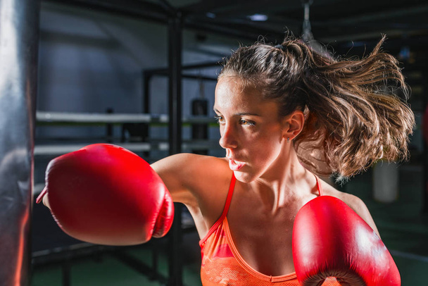 Женщина на боксерской тренировке с боксерской грушей
 - Фото, изображение