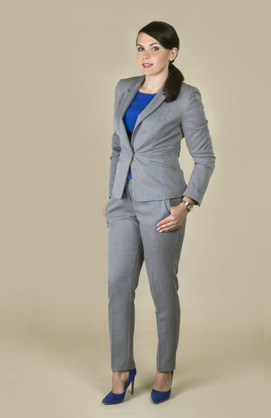 Brunette woman wearing gray suit isolated on plain background - Foto, imagen