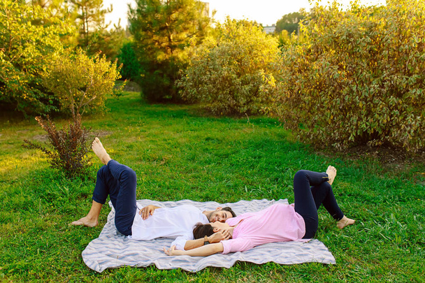 Young couple lying on grass and smiling and touching gently each other - Photo, Image