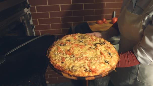 ピザの調理。スローモーション。女性の手のピザをオーブンから取り出すし、まな板に転送. - 映像、動画