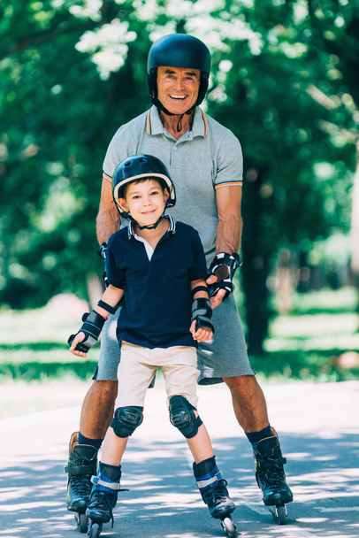 Nagyapa és unokája görkorcsolyázás a parkban portréja - Fotó, kép