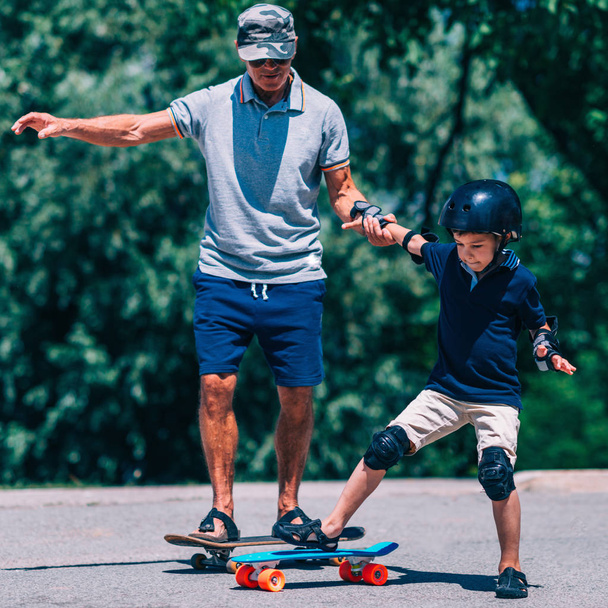 Grand-père et petit-fils skateboard ensemble
 - Photo, image