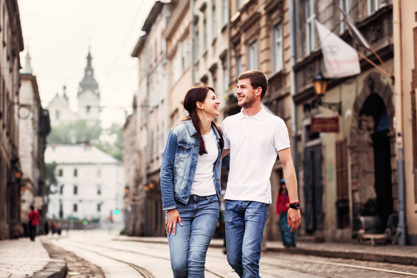 dziewczyna i chłopak, trzymając się za ręce, spacerując po ulicach starego miasta - Zdjęcie, obraz