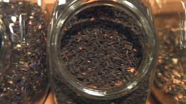 Varied varieties of flavored tea with additives.Top view. The camera moves ( from right to left ) over the jars in which there are different kinds of tea. - Footage, Video
