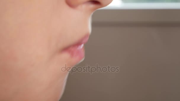 Close-up. kauwen de mond van de jongens. 4 k. de jongen likt zijn lippen. moeders hand veegt zijn lippen - Video