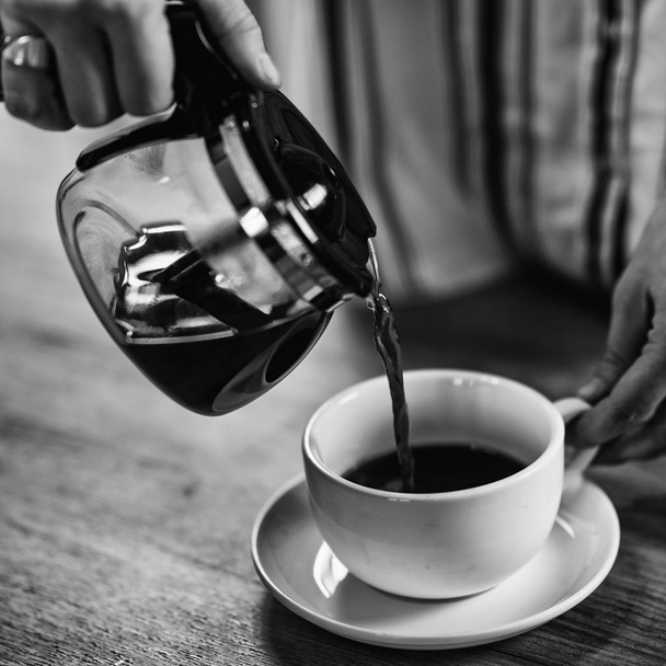 Frau gießt Kaffee aus Wasserkocher - Foto, Bild
