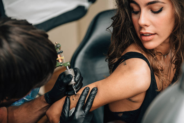 Una chica bonita haciéndose un tatuaje. Imagen tonificada
 - Foto, Imagen