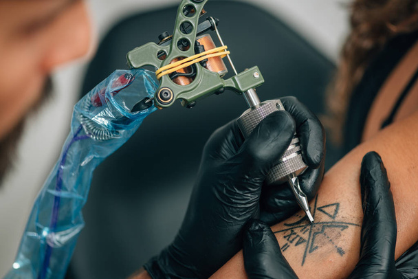 Tattoo művész tetoválás szálloda saj-a nő kezét. Tónusú kép - Fotó, kép