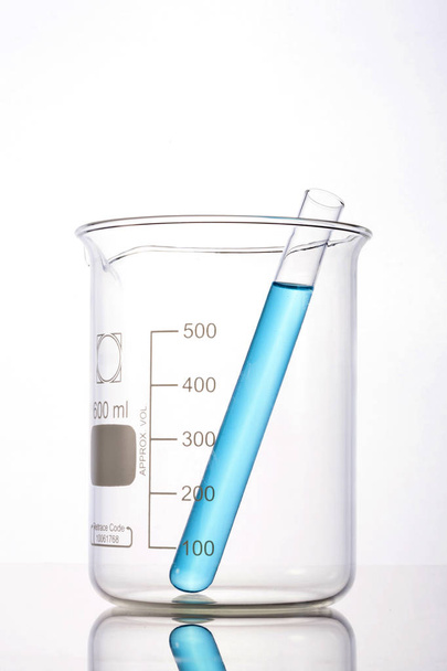 Cilindros graduados de laboratorio y vaso aislados sobre fondo blanco
 - Foto, imagen