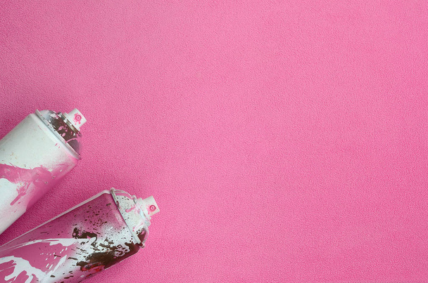 Alcune bombolette spray aerosol rosa usate con gocce di vernice si trovano su una coperta di tessuto morbido e peloso in pile rosa chiaro. Classico colore di design femminile. Graffiti hooliganism concetto
 - Foto, immagini