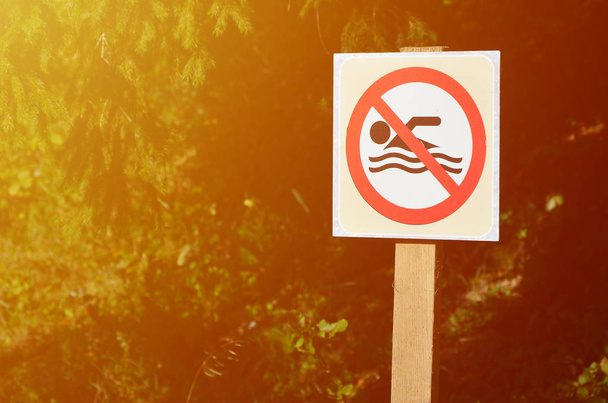 Un pilastro con un cartello che denota un divieto di nuoto. Il cartello mostra una persona fluttuante barrata
 - Foto, immagini