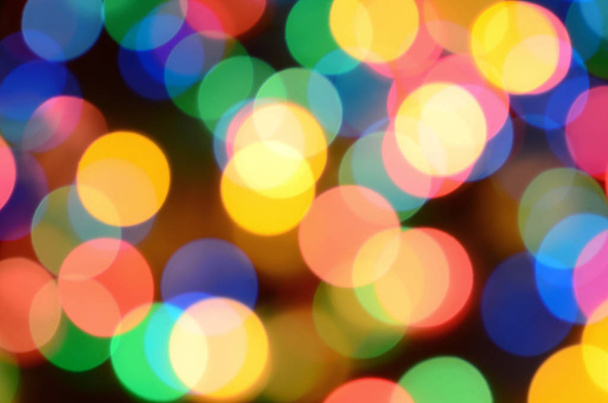 Blurred festive colorful lights over black useful as background. All main colors included. Red, yellow, green and blue - Photo, image