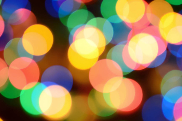Blurred festive colorful lights over black useful as background. All main colors included. Red, yellow, green and blue - Foto, Bild