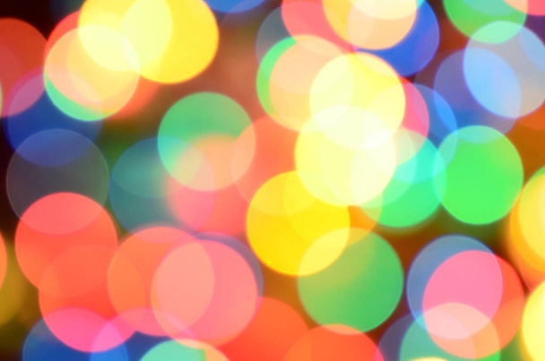 Blurred festive colorful lights over black useful as background. All main colors included. Red, yellow, green and blue - Photo, Image