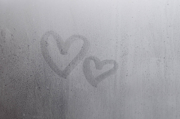 Couple de l'amour abstrait flou symbole de coeur dessiné à la main sur le verre de fenêtre humide avec fond de lumière du soleil. Modèle pour cartes postales de la Saint-Valentin
 - Photo, image