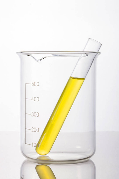 Cilindros de laboratorio y vaso de precipitados en mano aislados sobre fondo blanco
 - Foto, imagen