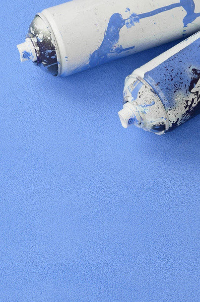 Algunos utilizan latas de aerosol azul con gotas de pintura se encuentra en una manta de suave y peludo tejido de lana azul claro. Color de diseño femenino clásico. Graffiti concepto de vandalismo
 - Foto, imagen