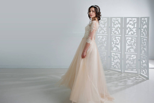 Portrait of a beautiful girl in a wedding dress. Bride in a luxurious dress, in a beautiful white interior - Foto, immagini