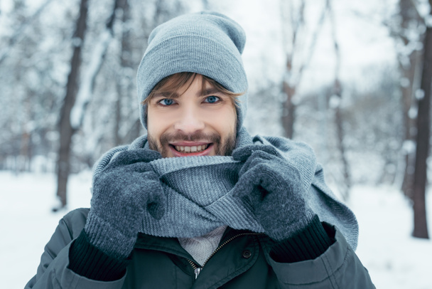 portrait of handsome smiling man looking at camera in winter park - Фото, изображение