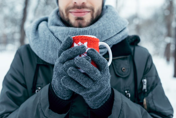 partial view of man holding cup of hot coffee in hands on winter day in park - Photo, Image