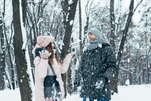 young couple having fun together in snowy forest - Foto, immagini