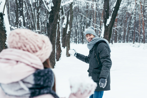 young couple having fun together in snowy forest - Foto, Imagen