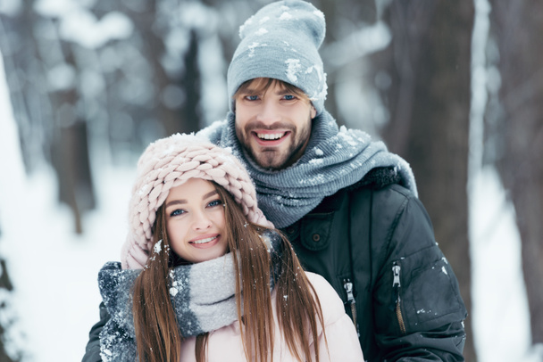 πορτρέτο του ευτυχισμένο ζευγάρι βλέπουν φωτογραφική μηχανή στο χιονισμένο πάρκο - Φωτογραφία, εικόνα