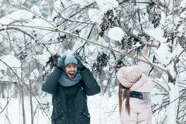 young couple having fun together in snowy forest - Foto, Bild