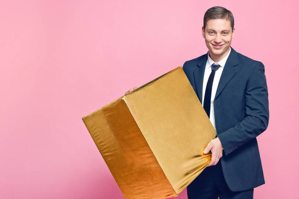 a man holding a big gold box - Foto, imagen