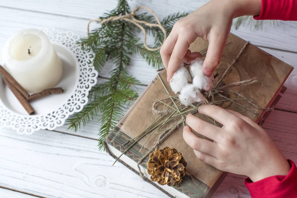 A cosy festive photo of a pair of childrens hands packing Christmas gifts  - Photo, Image