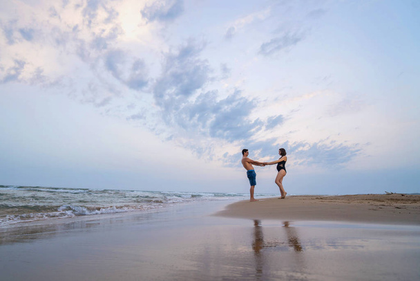 Pregnant couple walking on the beach - Foto, Imagen