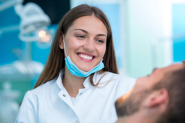 Dentist examining a patient's teeth in the dentist. - Фото, изображение