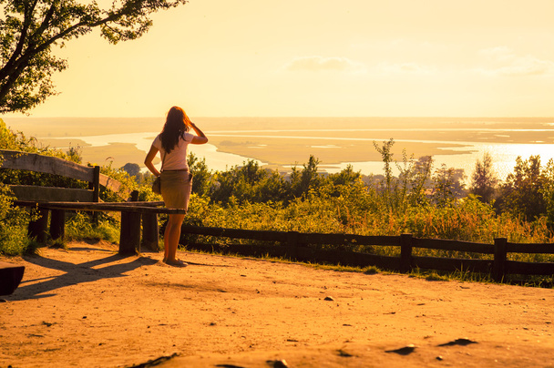κορίτσι βλέποντας λίμνες στο προσκήνιο κατά τη διάρκεια καταπληκτικό ηλιοβασίλεμα - Φωτογραφία, εικόνα