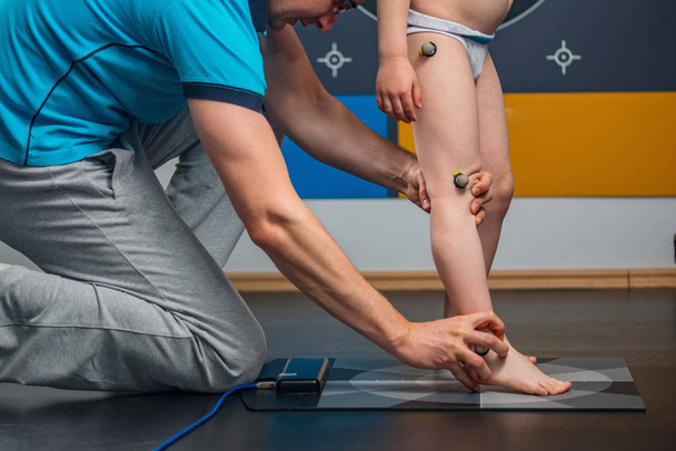 Fysikaalinen terapeutti Sijoittaminen heijastava merkintä pallot ryhti analyysi jaloissa
 - Valokuva, kuva