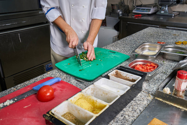 Chef sprinkling spices on dish in commercial kitchen - Foto, immagini