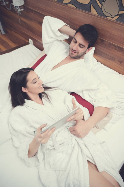 hotel, travel, relationships, and happiness concept - happy couple in bed - Фото, изображение