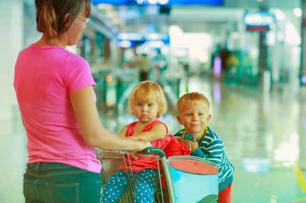 mother and two kids walking in the airport - Photo, Image