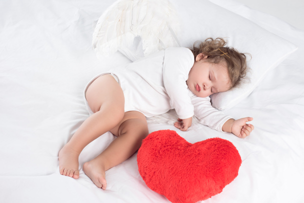 маленька дитина зі сном на ліжку з серцем, ізольована на білому
 - Фото, зображення